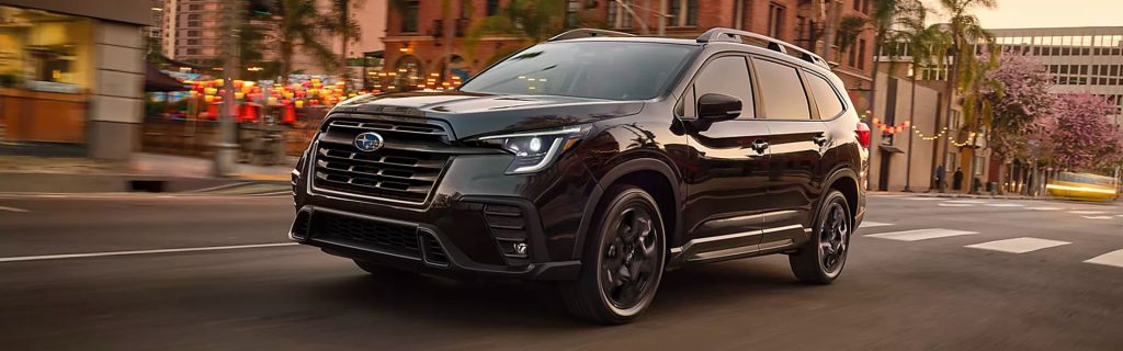 A black Subaru SUV driving through the city.