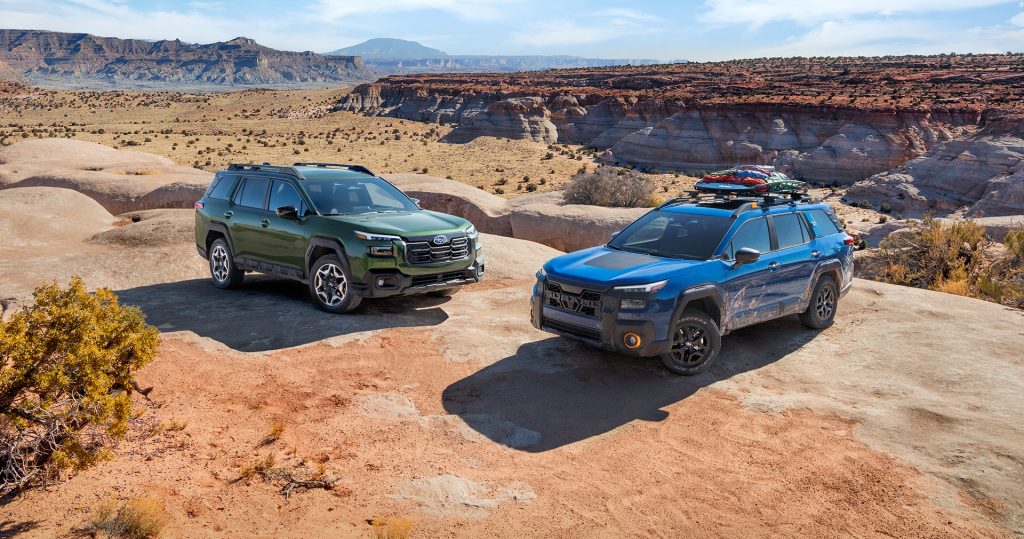 Green and blue SUVs parked in a desert landscape.
